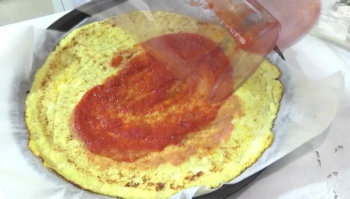 Stendere la passata di pomodoro sulla base della pizza.