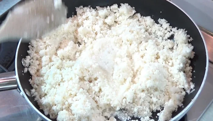 Tritare finemente il cavolfiore con un robot da cucina, fino a ottenere una consistenza simile al couscous.