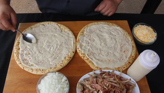 Stendere un cucchiaio di besciamella (o salsa barbecue bianca) su ciascuna base per pizza.