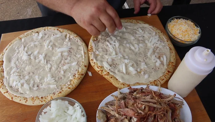 Aggiungere una miscela di mozzarella, Jack e cheddar su entrambe le basi.