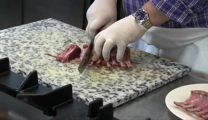 Tagliare le costolette d'agnello come mostrato nel video. Dare una leggera schiacciata.