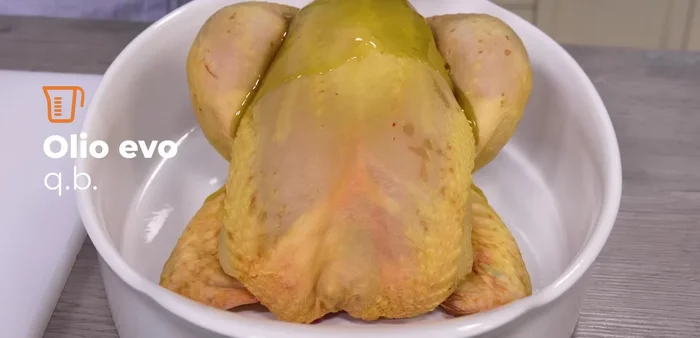 Massaggiare il pollo con olio extra vergine di oliva e il mix aromatico, sia all'esterno che all'interno.