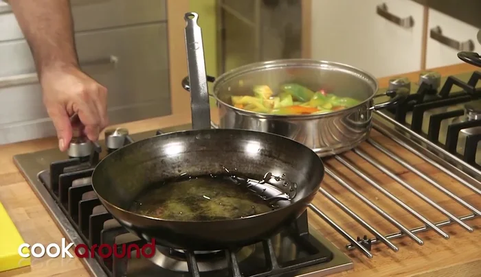 Preparare il contorno di peperoni agrodolci: in una padella, soffriggere zucchero, sale e peperoni cotti a vapore. Aggiungere aceto di vino bianco per dare acidità.