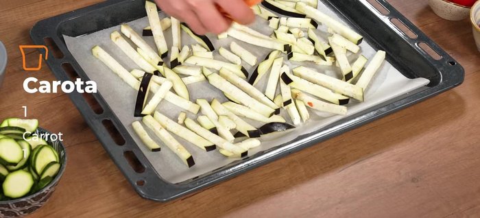 Preparazione delle verdure: Tagliare le melanzane, le carote, i peperoni e le zucchine a bastoncini (carote più piccole), le zucchine a rondelle di 1 cm e le cipolle a fette più spesse. Distribuire le verdure su una teglia, condire con sale, pepe, aglio schiacciato, rosmarino, timo fresco e olio.