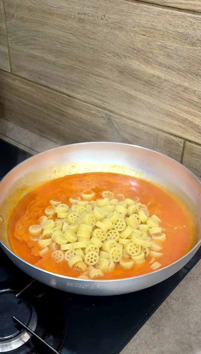 Scolare la pasta e aggiungerla alla padella con la crema di peperone e pancetta. Far cuocere per altri 3 minuti.