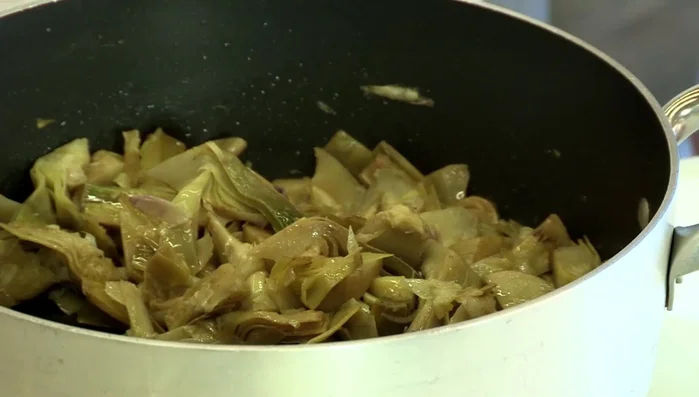 Riempire il coniglio con i carciofi cotti e legarlo con lo spago da cucina.