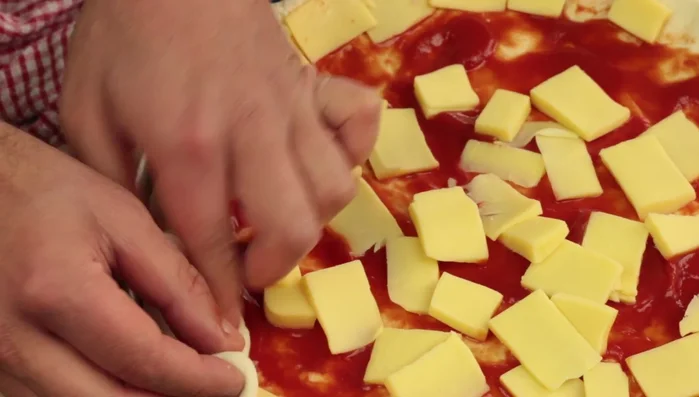 Aggiungere il salame piccante sulla pizza. [83.2]