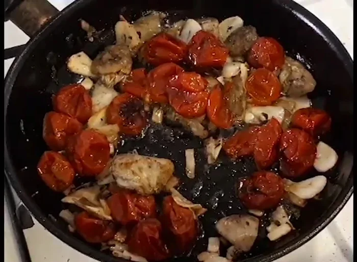 Rosolare i pomodori con l'aglio e i carciofi fino a quando l'aglio non diventa traslucido e il composto è ben amalgamato.