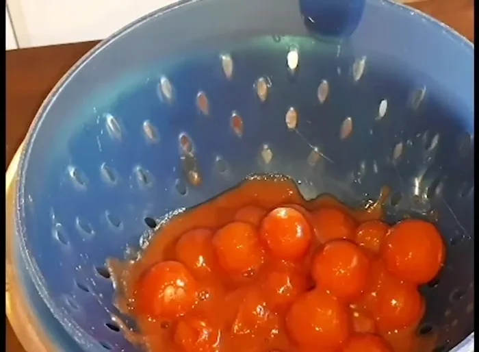 Scolare i pomodorini ciliegini in scatola e conservare il succo. Rovesciarli su un tappetino di silicone su una teglia, irrorarli con un filo d'olio d'oliva e cospargerli di sale marino.