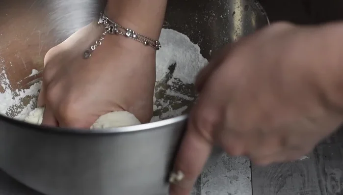 Impastare con le mani per circa 5 minuti. Aggiungere 20 g di olio extravergine d'oliva e continuare a mescolare.