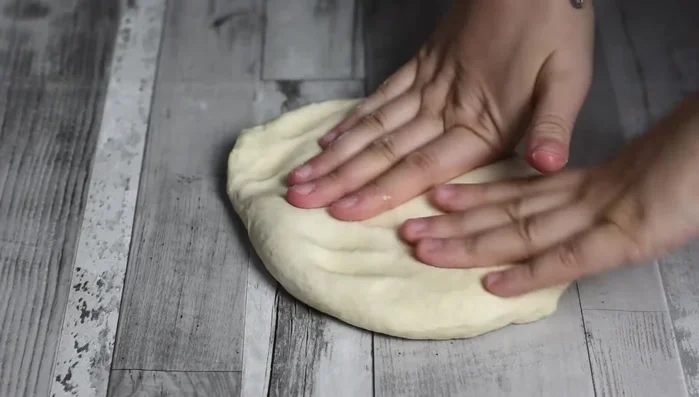 Dopo 6 ore, riprendere l'impasto e stenderlo sulla spianatoia, non troppo sottile né troppo spesso.