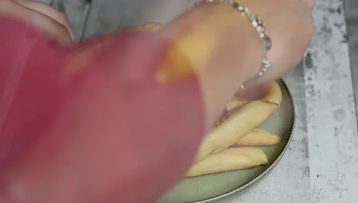 Servire gli scugnizzi su un piatto con pomodorini tagliati a dadini, parmigiano grattugiato e rucola. Aggiungere un pizzico di sale se necessario.
