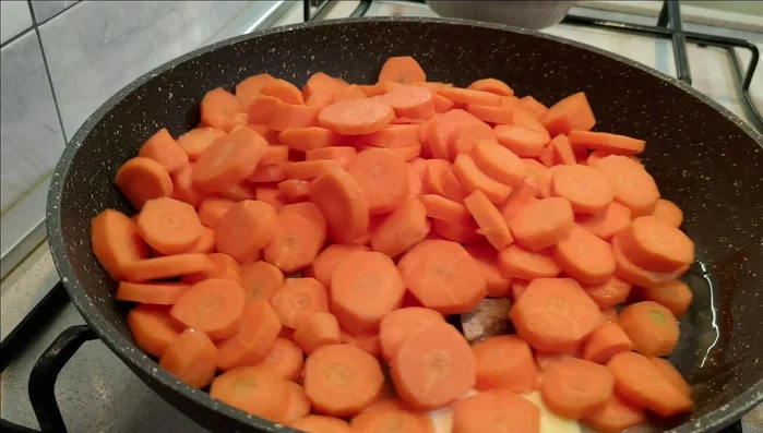 Aggiungete le carote nella padella, unite una tazzina d'acqua e coprite con un coperchio.