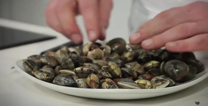 Lavare le vongole sotto acqua corrente fredda e rimuovere eventuali vongole rotte.
