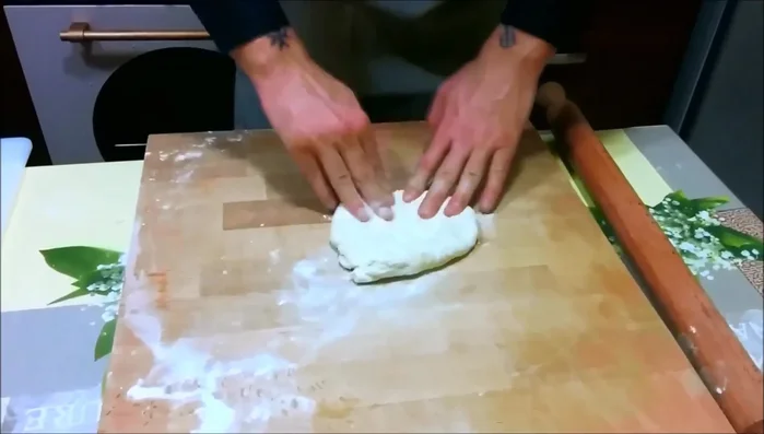 Prendere un pezzo di impasto e stenderlo sul piano di lavoro con l'aiuto di un mattarello.