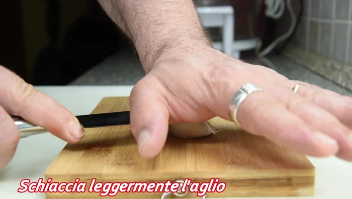 Schiacciare leggermente l'aglio.