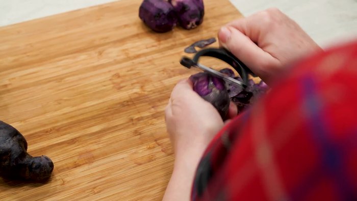 Pulire le patate e le carote, pelandole e eliminando le estremità. Tagliare le patate a cubetti e le carote a fette.