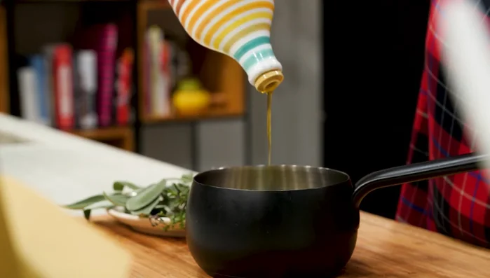 Preparare l'olio aromatizzato: unire olio, erbe aromatiche e peperoncino. Soffriggere per aromatizzare l'olio, poi spegnere e lasciare intiepidire.