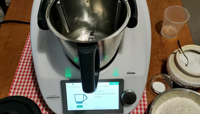 Preparare l'impasto nel Bimby: versare 250 g di acqua, 5 g di lievito di birra, 1 cucchiaino di zucchero. Impostare 2 minuti, 37 gradi, velocità 3.