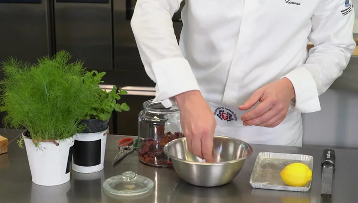 Preparare le briciole di peperone crusco: sbriciolare i peperoni e aromatizzare con scorza di limone, finocchietto e menta. (409.57)