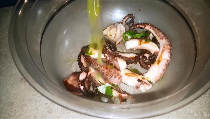 Aggiungere il condimento preparato al polpo grigliato.