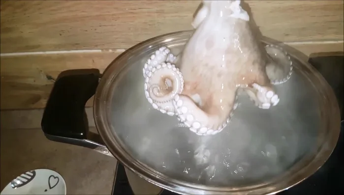 Immergere il polpo nell'acqua bollente per circa 20 minuti per farlo arricciare (shock termico).