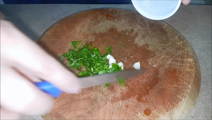 Mentre il polpo cuoce, preparare il condimento: tritare finemente il prezzemolo, aggiungere uno spicchio d'aglio tritato, un pezzettino di peperoncino, un pizzico di sale, un filo d'olio extravergine di oliva e il succo di un limone. Mescolare bene e mettere in frigorifero coperto per circa 30 minuti.