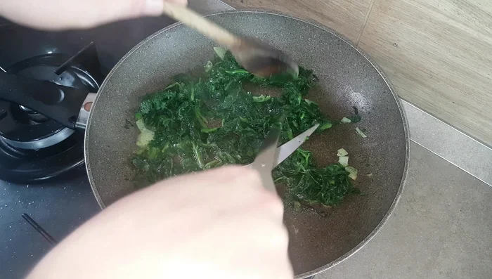 Tritare finemente gli spinaci con le forbici.