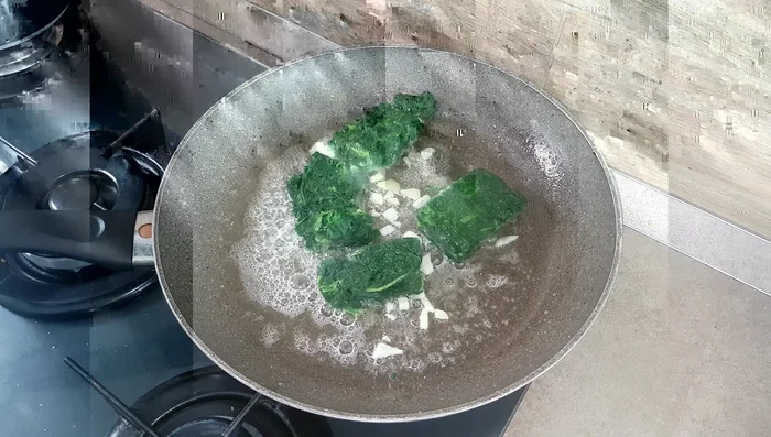 Aggiungere gli spinaci (surgelati o freschi). Se freschi, cuocere per circa 10 minuti; se surgelati, per circa 20 minuti a fiamma dolce, coperto.