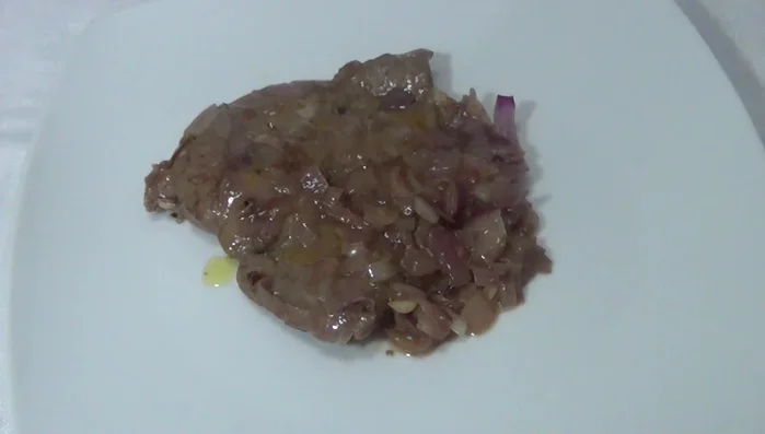 Servire il fegato alla veneziana caldo, irrorato con un filo d'olio extravergine di oliva a crudo e, se gradito, guarnito con prezzemolo fresco tritato.