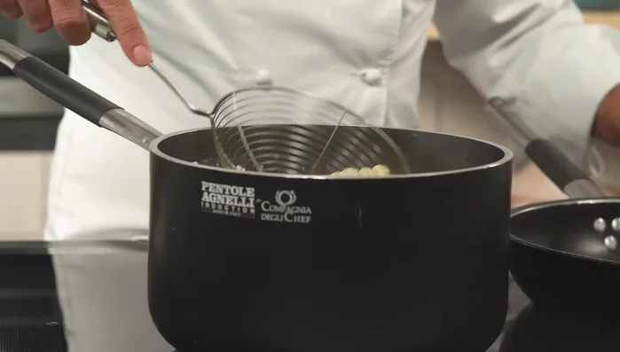 Scolare le busiate e aggiungerle in una padella con una noce di burro e il pesto trapanese.