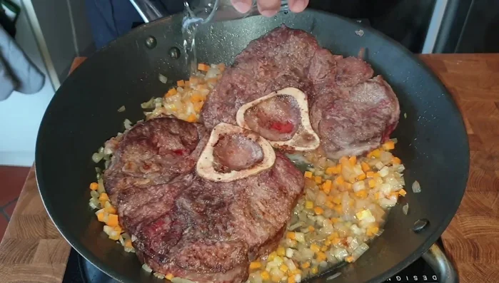 Rimettere l'ossobuco in padella, aggiungere il vino bianco e farlo evaporare (307.16)