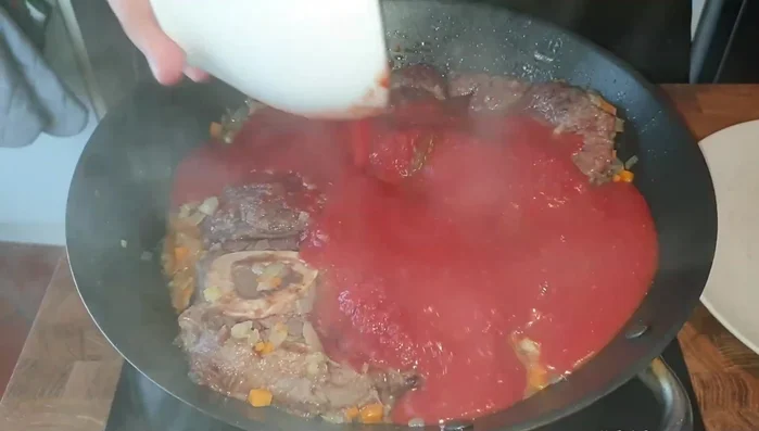 Aggiungere la salsa di pomodoro, salare e pepare, e cuocere a fuoco lento per circa 1 ora e 15 minuti (325.36)