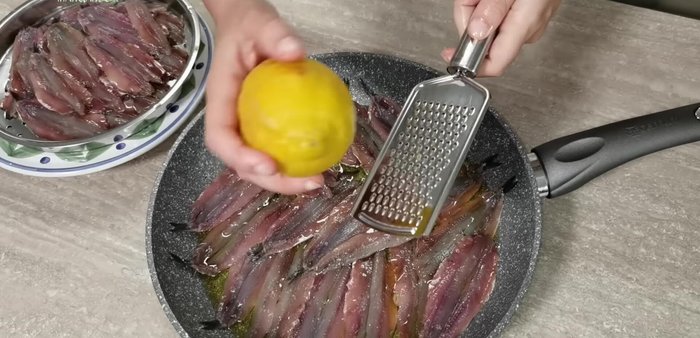 Condite con sale, pepe nero e scorza di limone. Ripetete gli strati di alici, condimento, sale, pepe e scorza di limone.