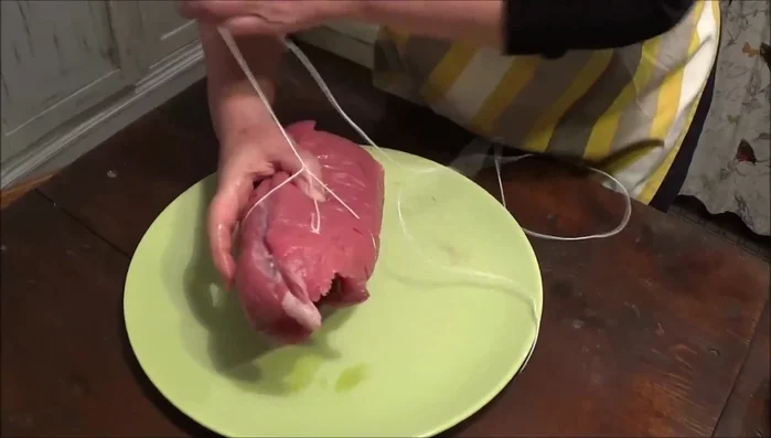 Arrotolare la carne con la frittata, aiutandovi con lo spago da cucina per legare bene (231.7).