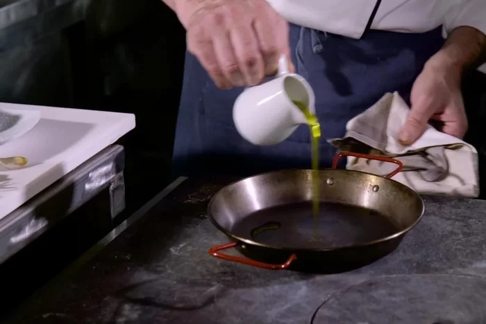 Rosolare il vitello in una padella con abbondante olio, aggiungendo lo spicchio d'aglio in camicia.