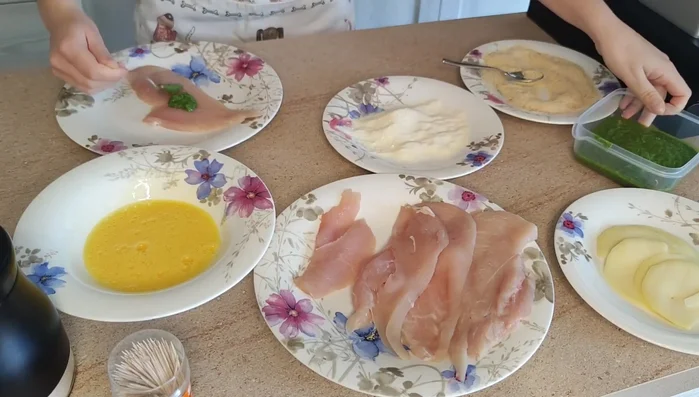 Preparare gli involtini: spalmare il pesto di rucola su ogni fetta di pollo, aggiungere il formaggio e arrotolare, chiudendo con uno stuzzicadente (274.74).