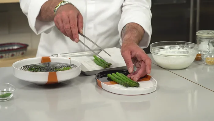 Impiattare: disporre gli asparagi sul piatto, aggiungere la salsa allo yogurt con sesamo tostato, peperoncino e olio all'erba cipollina (118.88).