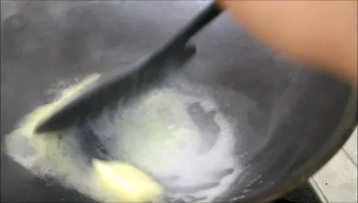 Preparare il condimento al pollo: sciogliere il burro in una padella calda. Aggiungere aglio, pepe e peperoncino in polvere. Friggere a fuoco basso per circa un minuto, evitando di bruciare le spezie.