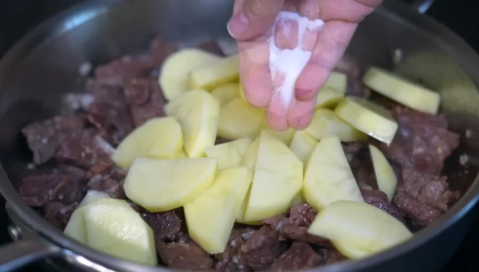 Aggiungere le patate scolate e cuocere per 5 minuti. Versare la salsa, condire con sale e brodo di pollo, mescolare bene e abbassare la fiamma.