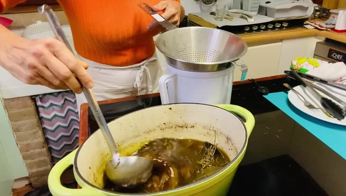 Filtrare il fondo di cottura dello stracotto e ridurlo sul fuoco fino ad addensarlo.