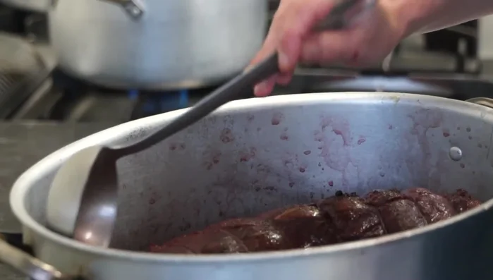 Una volta evaporato il vino, aggiungere il brodo di carne poco alla volta, mantenendo il bollore.