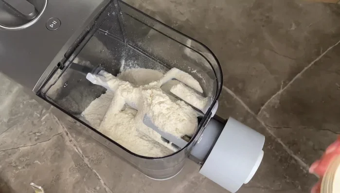 Mescolare le due farine nel contenitore della macchina per la pasta.