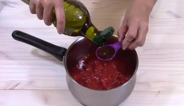 Preparare la salsa di pomodoro: In una pentola, cuocere a fuoco basso i pomodori a cubetti con un cucchiaio di olio d'oliva e sale, fino a far evaporare il succo.