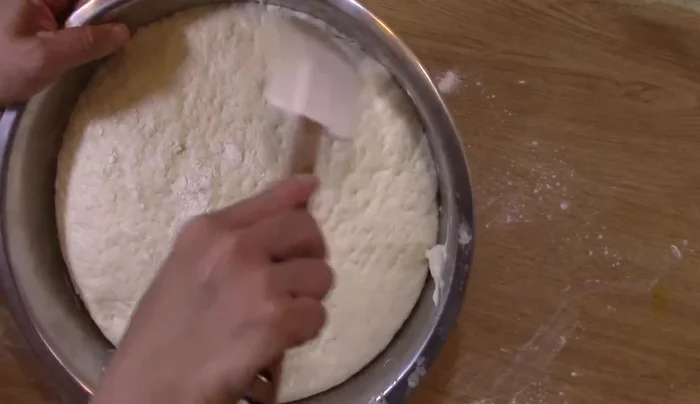 Stendere l'impasto: Tirare fuori l'impasto e stenderlo con un mattarello su una teglia da forno rivestita di carta forno.