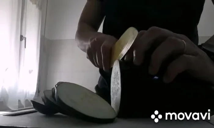 Tagliare le melanzane a fette e friggerle in olio caldo fino a doratura. Farle poi sgocciolare su carta assorbente.