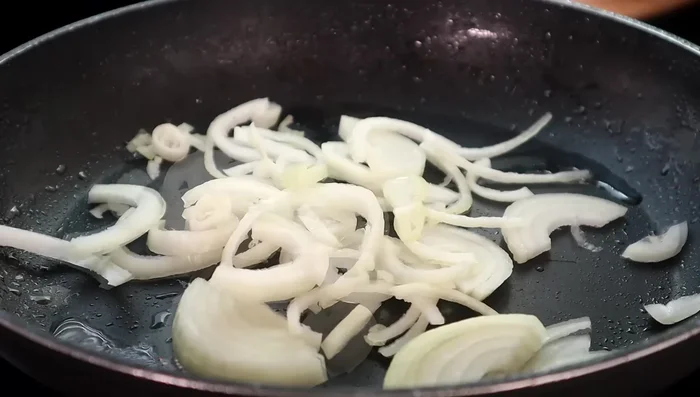 Nella stessa padella, aggiungere altro olio vegetale e rosolare le cipolle e i peperoni rossi per 2-3 minuti, finché non si saranno ammorbiditi.