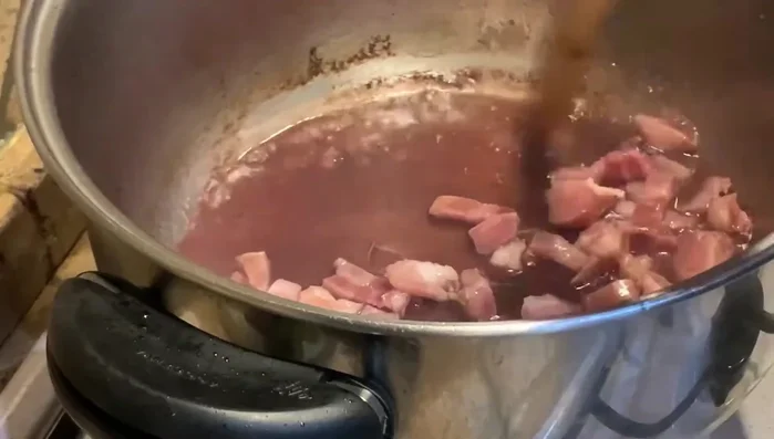 Aggiungere la pancetta tagliata a cubetti nella pentola con il vino residuo e farla sciogliere a fuoco vivo.