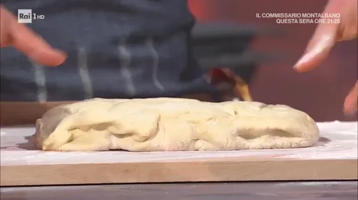 Dopo 12 ore, stendere l'impasto su un piano infarinato, formando un rettangolo. (273.37)