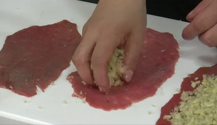 Sistemare le fettine di carne sul tagliere, disporre al centro la farcia, lasciando liberi i bordi (104.339). Chiudere gli involtini arrotolando senza stringere troppo (116.64). Infilare con due spiedini per mantenerli fermi (129.08).